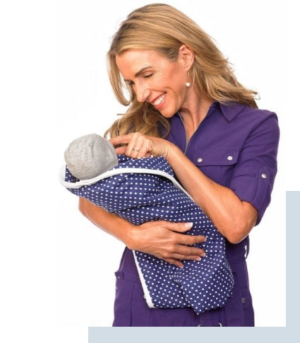 Healthcare worker holding infant wearing navy polka dot SYB Baby Beanie, demonstrating fit and use.