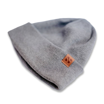Gray SafeSleeve Beanie with brown leather patch logo, displayed folded on white background, detail view.