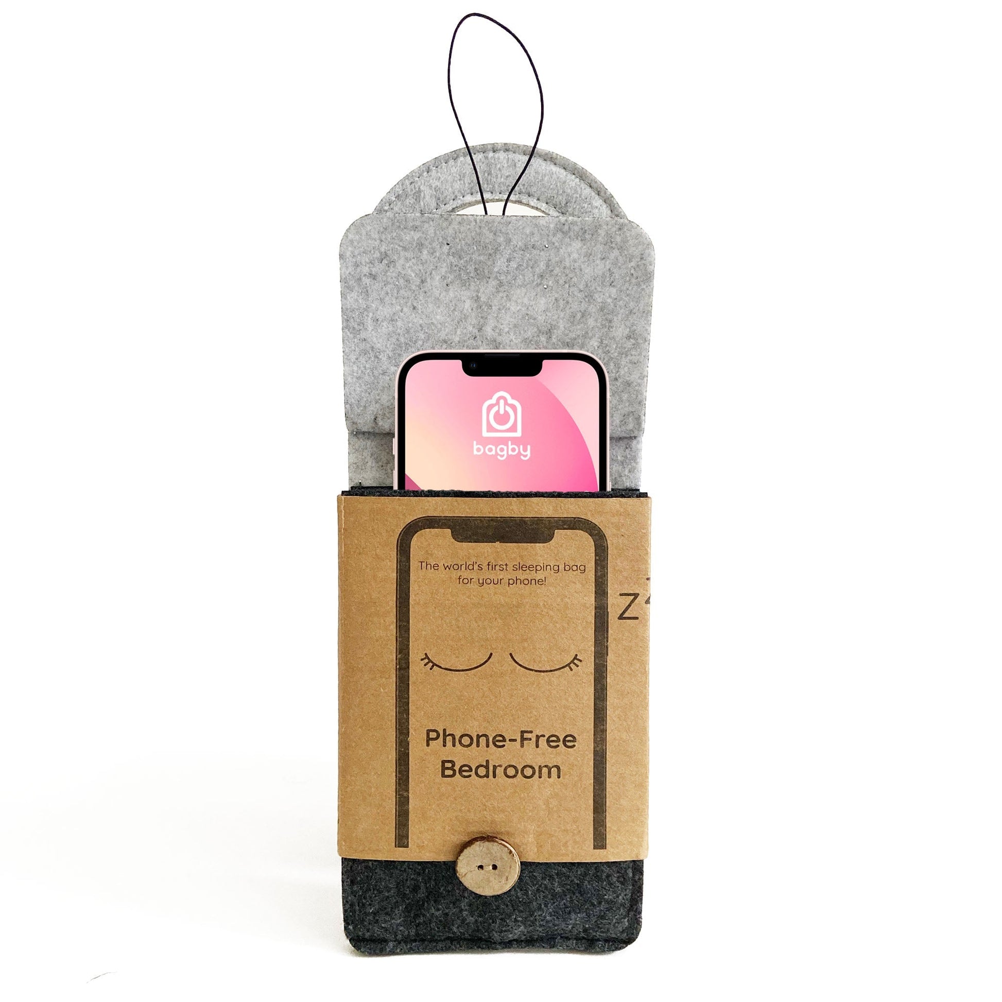 Bagby phone sleeping bag displayed with a smartphone inside the gray felt pouch, showing the kraft paper band labeled "Phone-Free Bedroom" with hanging loop.
