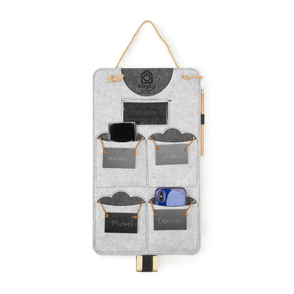 Bagby 4 Pocket Phone Holder wall organizer in light gray felt with four labeled pockets, hanging by rope cord, displaying personalized names and a smartphone.