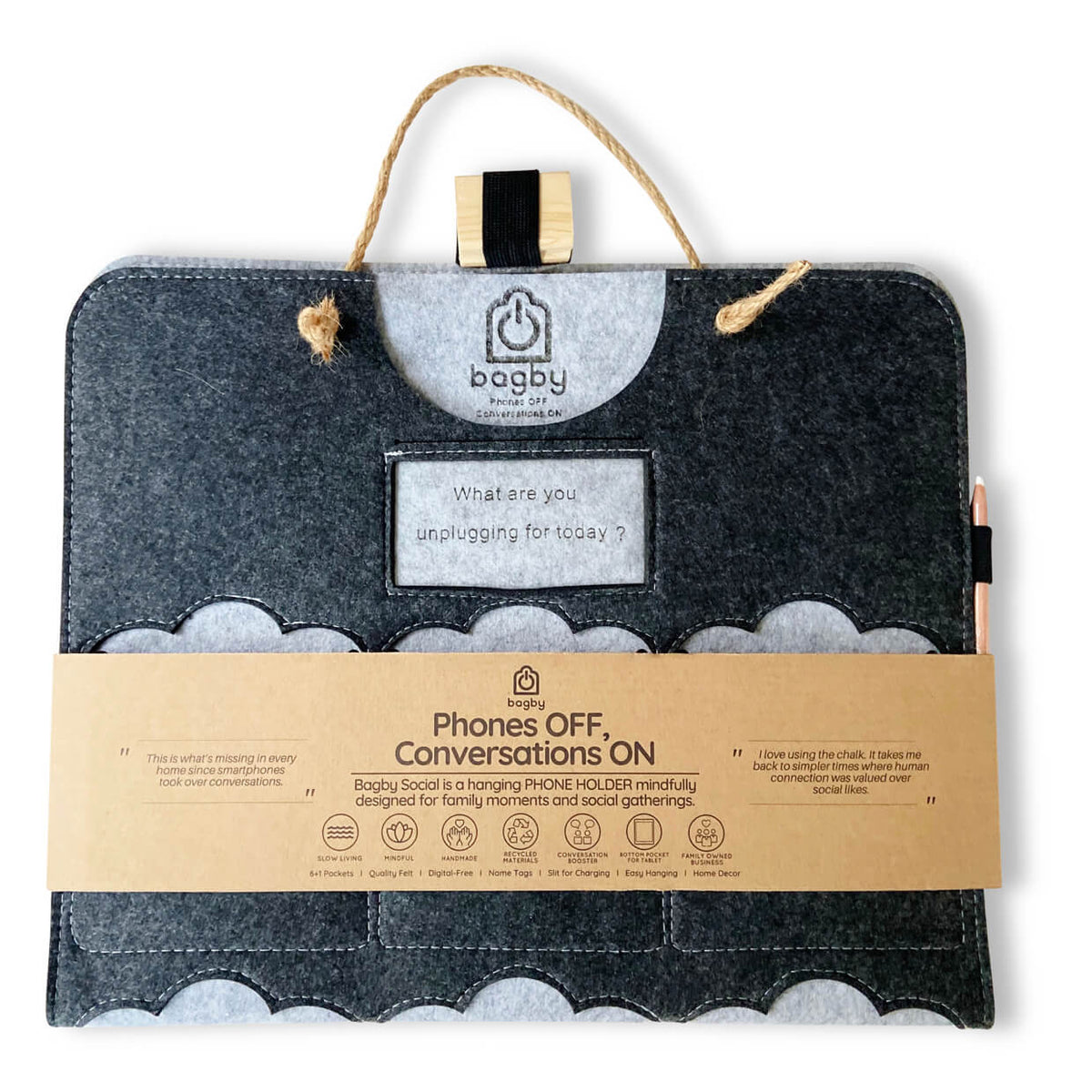Dark gray Bagby FAMILY organizer folded in its kraft paper band reading "Phones OFF, Conversations ON", with rope hanger and pencil.
