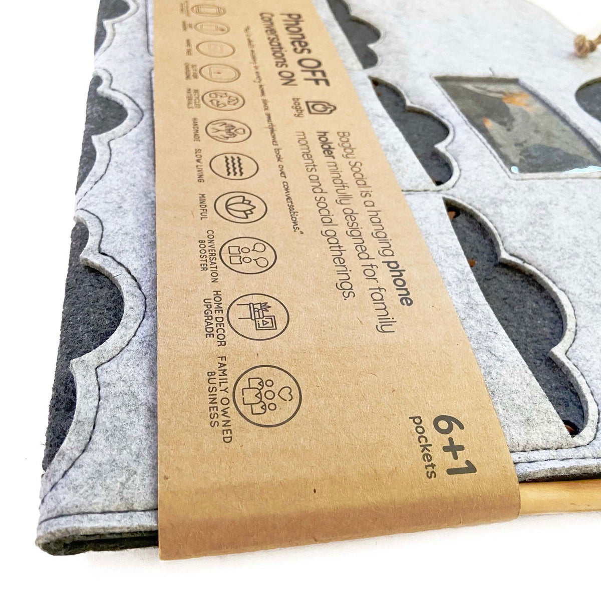 Close-up of the Bagby FAMILY kraft paper band showing icons for recycled materials, handmade construction and slow living.