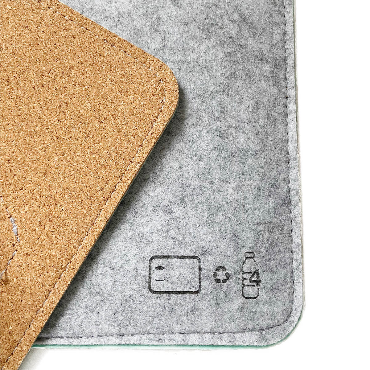 Close-up of the Bagby MAT's corner showing its cork non-slip backing, mint felt edge and stitched material-care icons.