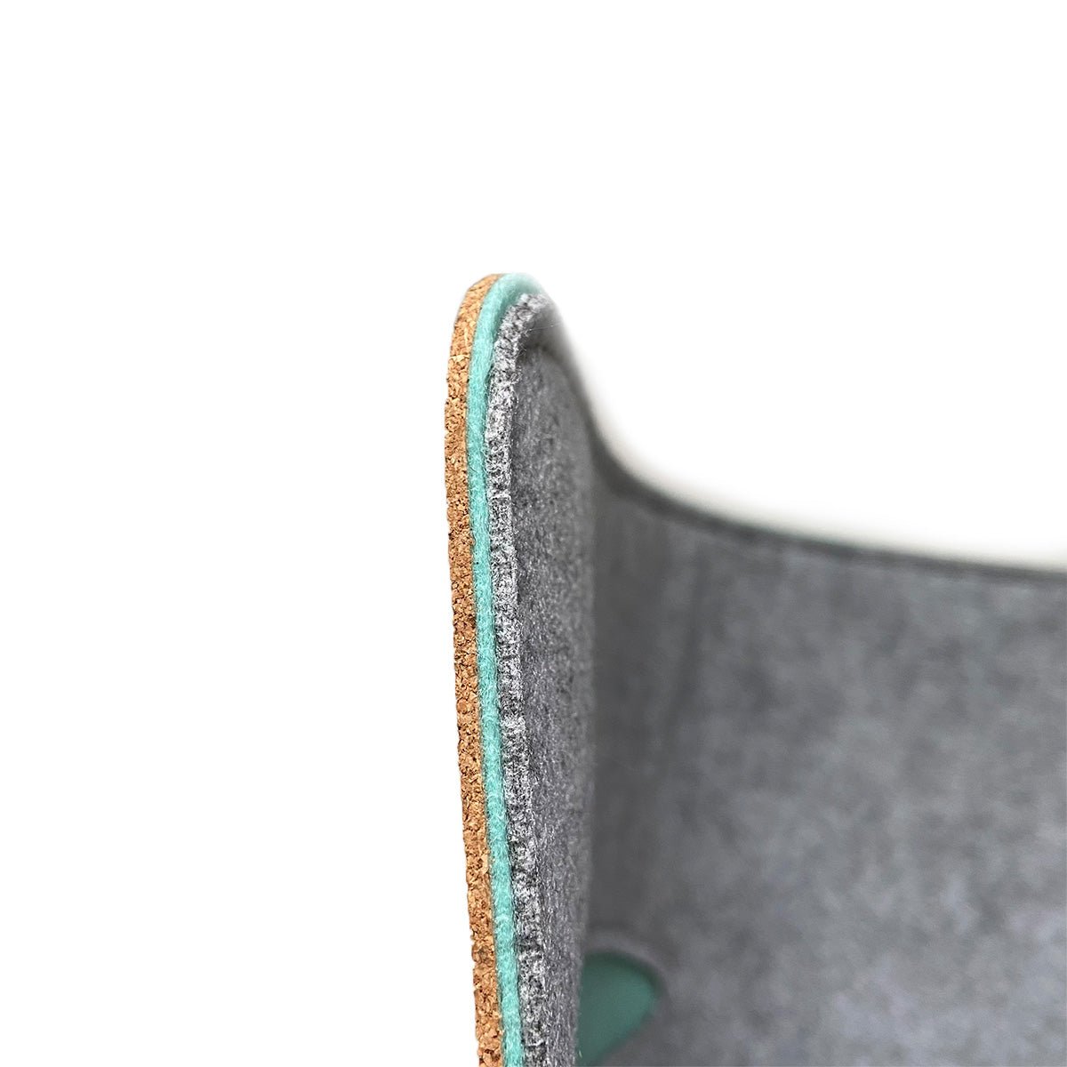 Close-up side view of the Bagby MAT's edge showing the layered cork backing, mint felt and gray felt surface.