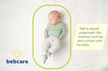 Bebcare Mat Smart Breathing Sensor positioned under crib mattress beneath sleeping infant in green shirt and light pants.