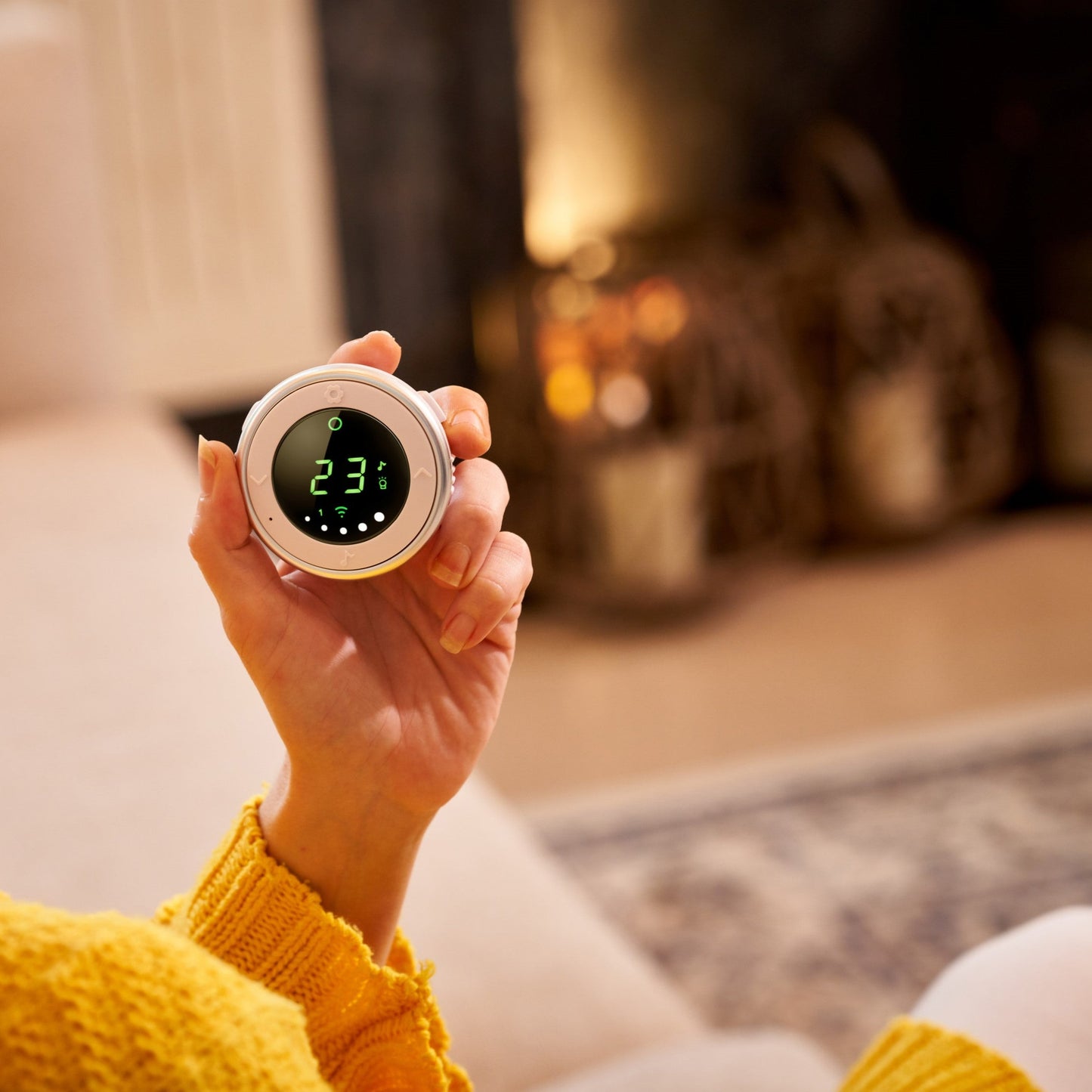 Hand holding Bebcare Low-EMF digital audio baby monitor displaying 23°C temperature on screen.