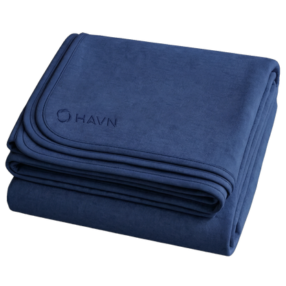 HAVN WaveStopper™ Blanket folded in navy blue with embroidered logo visible on top corner.