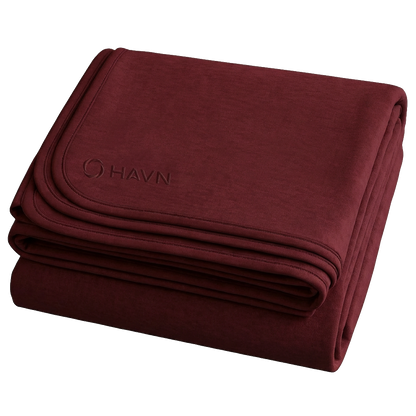 HAVN WaveStopper™ Blanket folded in burgundy, showing the brand logo on the top layer against a white background.