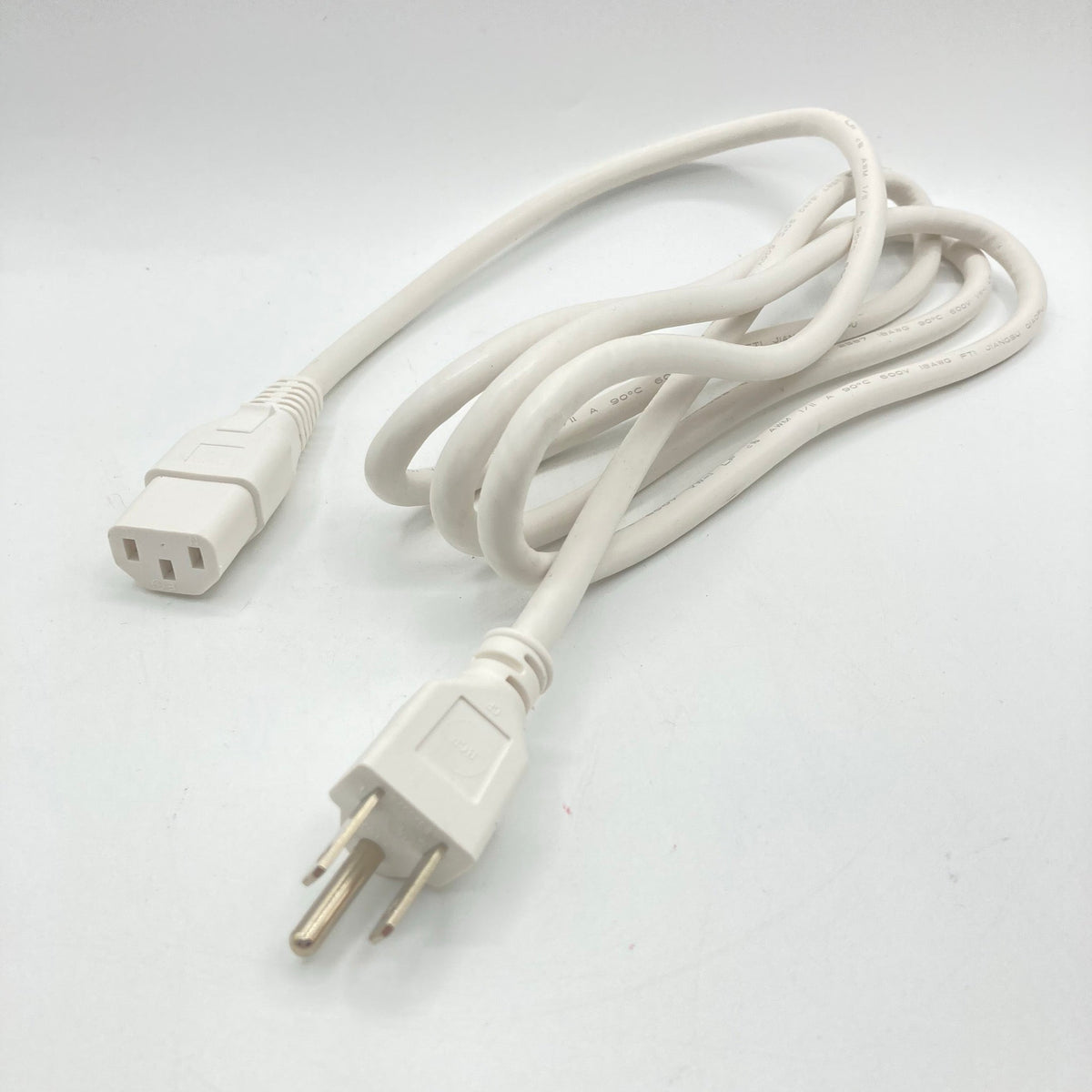 White power cord with a straight three-prong grounded plug and a C13 connector, loosely coiled on a white surface.