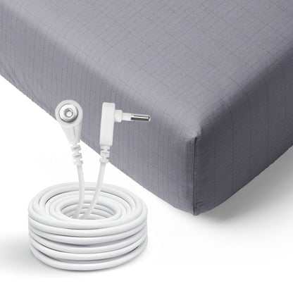 GroundLuxe Organic Fitted Grounding Sheet with white coiled cord and connector attached to gray quilted mattress corner.