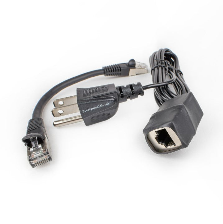 Black grounding adapter with its Ethernet port showing, next to the short patch cable and the grounding cord's three-prong plug.