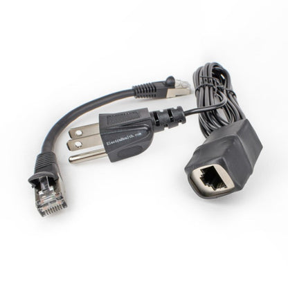 Black grounding adapter with its Ethernet port showing, next to the short patch cable and the grounding cord's three-prong plug.
