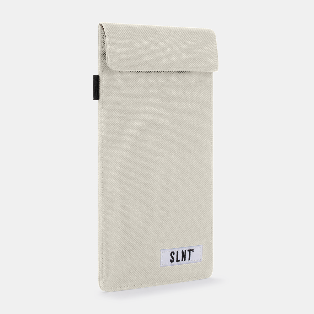 Cream-colored Faraday Key Fob Bag with SLNT label, featuring a fold-over flap closure and black pull tab on the side.