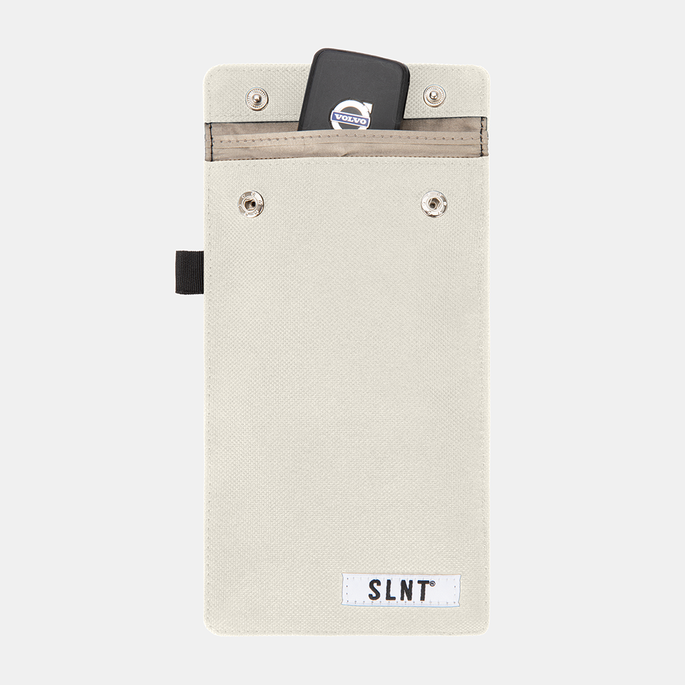 Faraday Key Fob Bag in cream canvas with a smartphone and key fob displayed in the top pocket, front view.