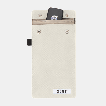 Faraday Key Fob Bag in cream canvas with a smartphone and key fob displayed in the top pocket, front view.