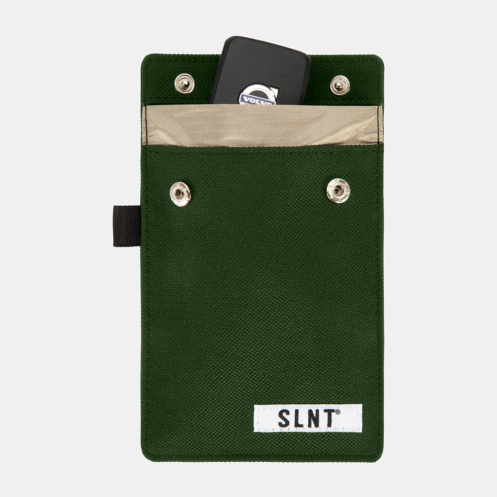 Green Faraday Key Fob Bag with open top compartment revealing a black key fob inside, four metal grommets, beige interior pocket, and black side strap.