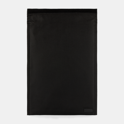 SLNT Faraday Laptop Bag in black, flat lay front view showing minimalist design with small logo patch in lower right corner.