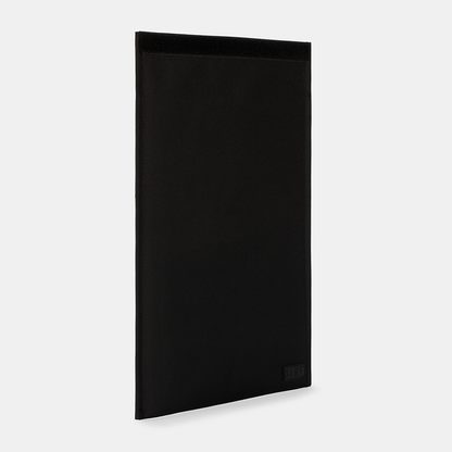 SLNT Faraday Laptop Bag in black, angled front view showing textured fabric surface and subtle branding on lower corner.