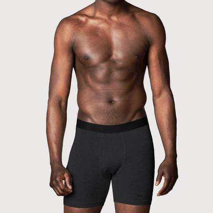 Shirtless man wearing black HAVN WaveStopper™ Boxer Briefs 2.0 with elastic waistband, front view.