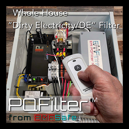 Hand holding EMFSafe PQFilter™ remote control in front of open electrical panel with internal wiring and components visible.