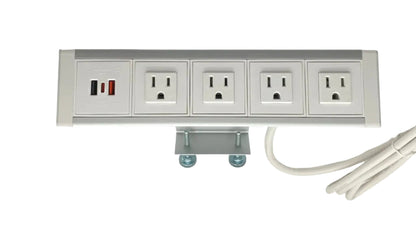 Desk-mountable power dock with four outlets and a USB panel, clamped under a tabletop edge with its white cord coiled beside it.
