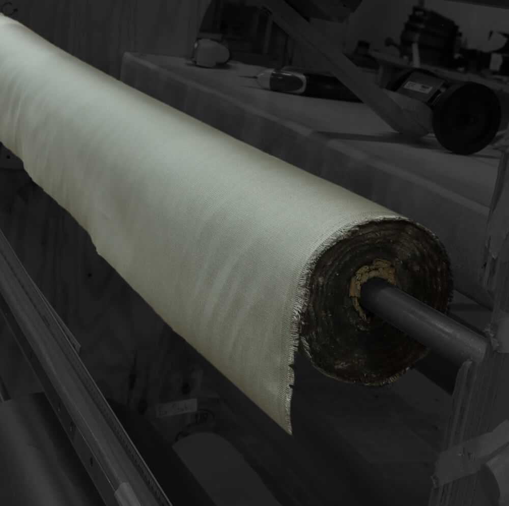 TechniCot Shielding Fabric rolled on a tube, showing white woven material with dark backing.