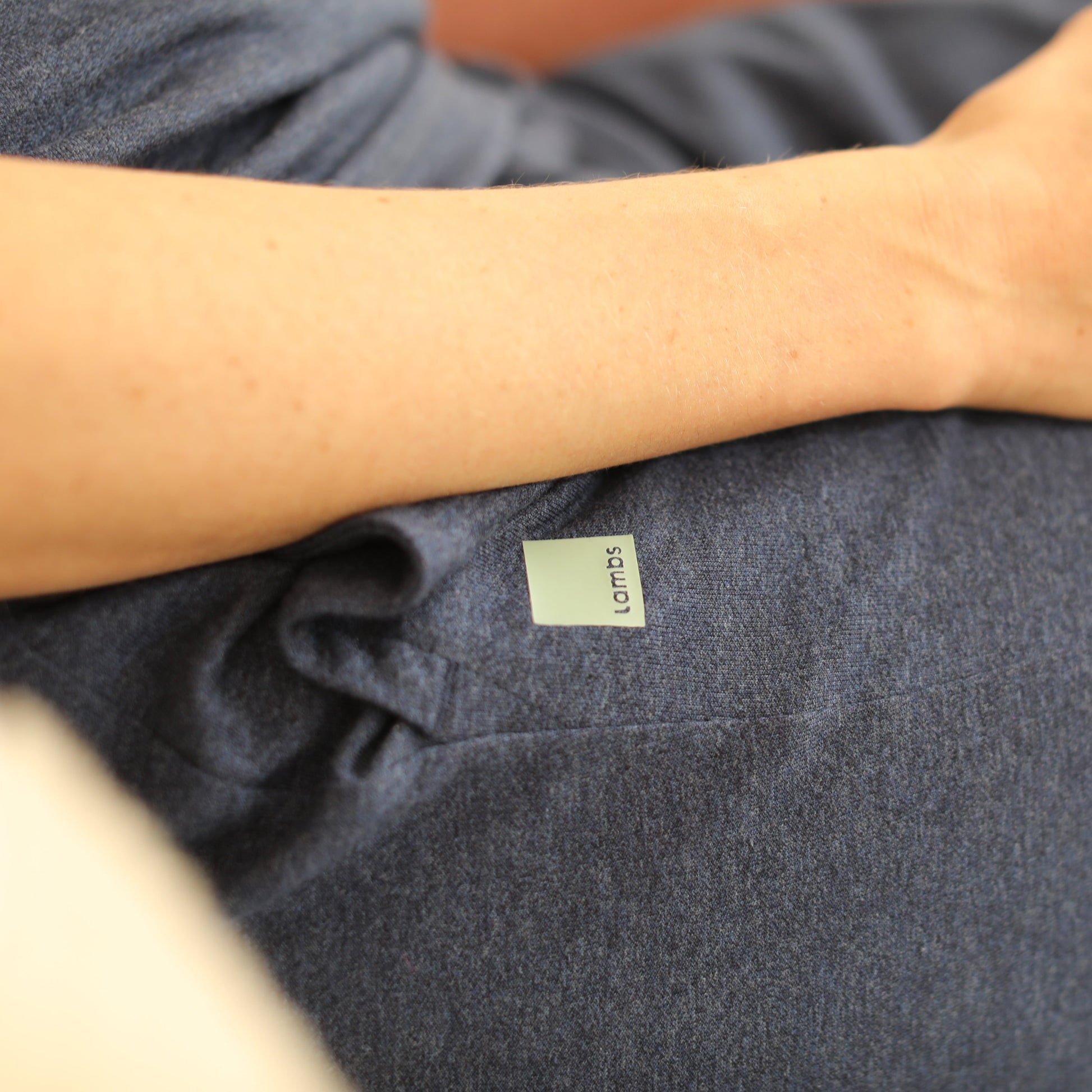 Person wearing dark gray HAVN WaveStopper™ Pajama Set with visible brand label on sleeve, arm resting on fabric.