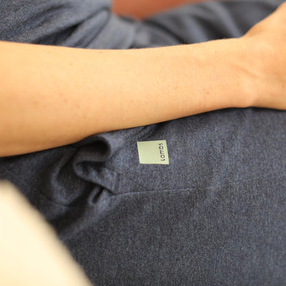 Person wearing dark gray HAVN WaveStopper™ Pajama Set with visible brand label on sleeve, arm resting on fabric.