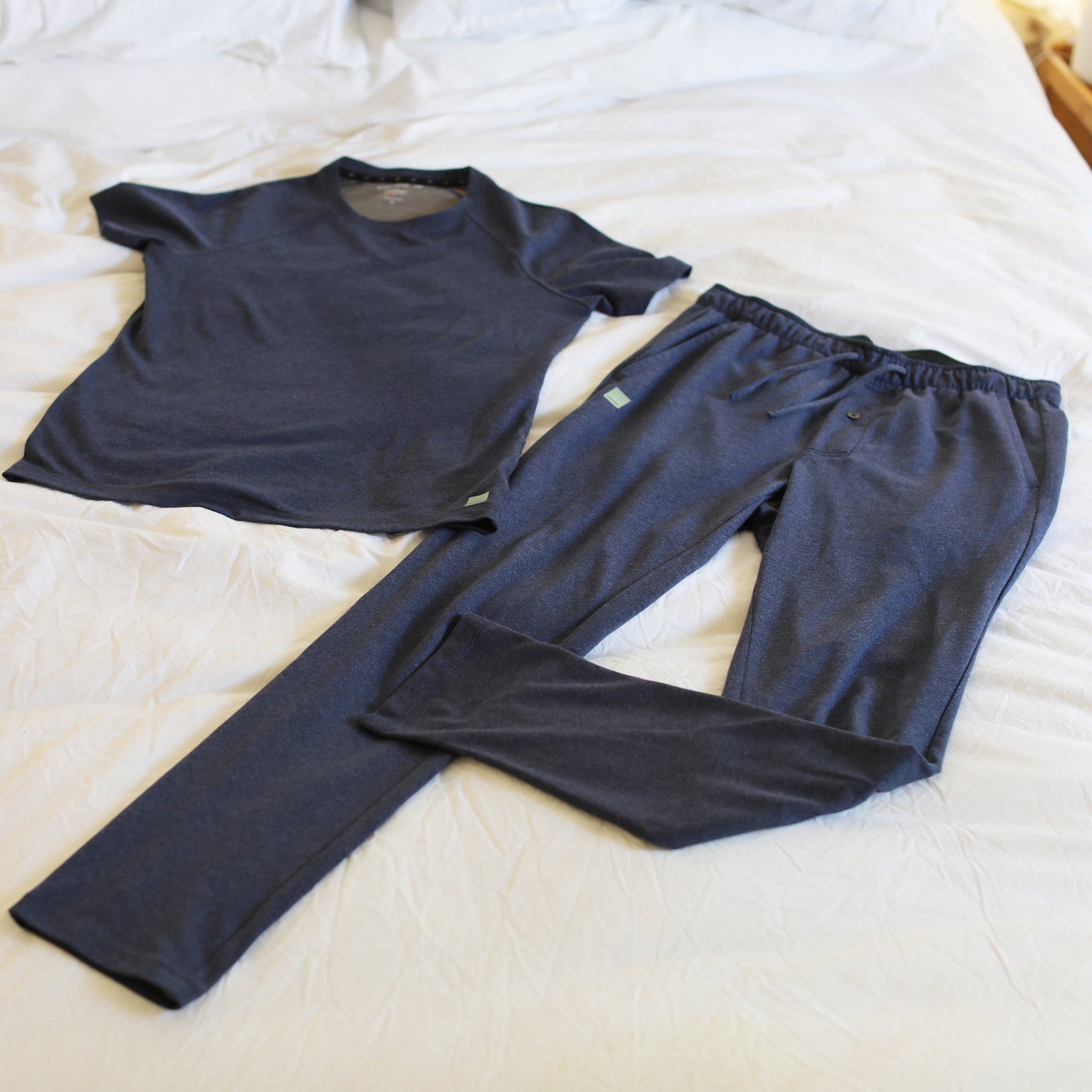 Navy HAVN WaveStopper™ Pajama Set laid flat on white bedding, showing short-sleeve t-shirt and matching pants.