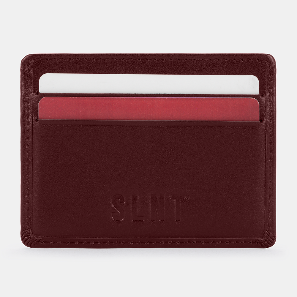 SLNT RFID Wallet in burgundy leather displaying card slots with white and red cards inserted, front view.