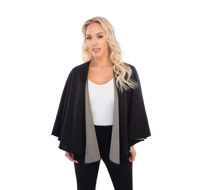 Woman wearing black and silver cotton double knit cape over white ribbed top and black pants, front view.