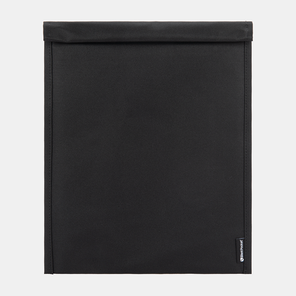 SLNT Faraday Laptop Bag closed flat lay view showing black textured fabric exterior with brand label on lower right corner.