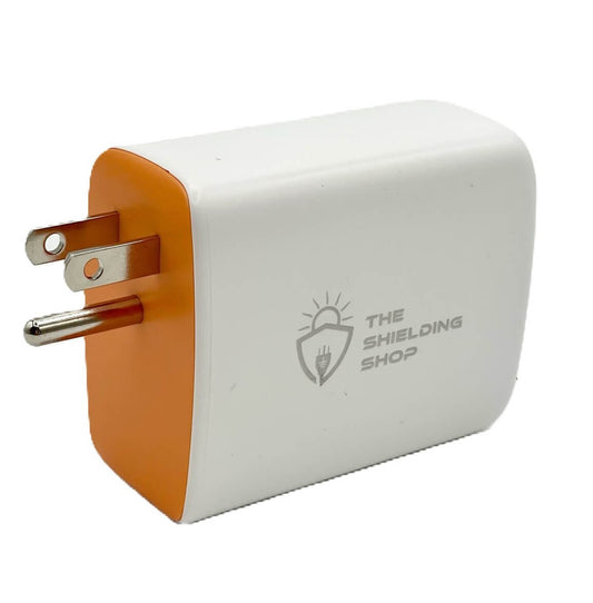 White wall charger with an orange side panel and a three-prong grounded plug, with a small engraved vendor logo on its face.