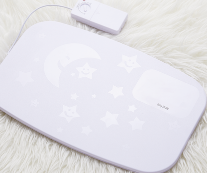 Bebcare Smart Breathing Sensor Mat displayed on white fur with control unit and cable, showing moon and star pattern design.