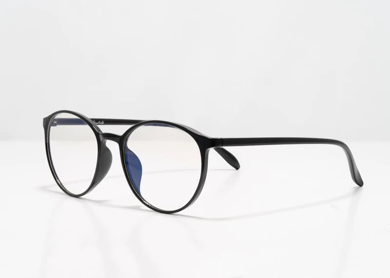 Black rounded Ocushield Clear All-Day Blue Light Glasses displayed at three-quarter angle against white background.