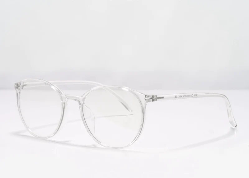 Clear frame Ocushield All-Day Blue Light Glasses displayed at angle on white background, showing side profile view of the transparent acetate frame design.