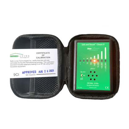 Safe and Sound Classic II RF detector in open carrying case showing green display screen with signal strength bars and control buttons, with calibration certificate visible on left side.