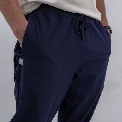 Man wearing navy HAVN WaveStopper™ Joggers with drawstring waist and side pockets, white shirt visible, front-side view.