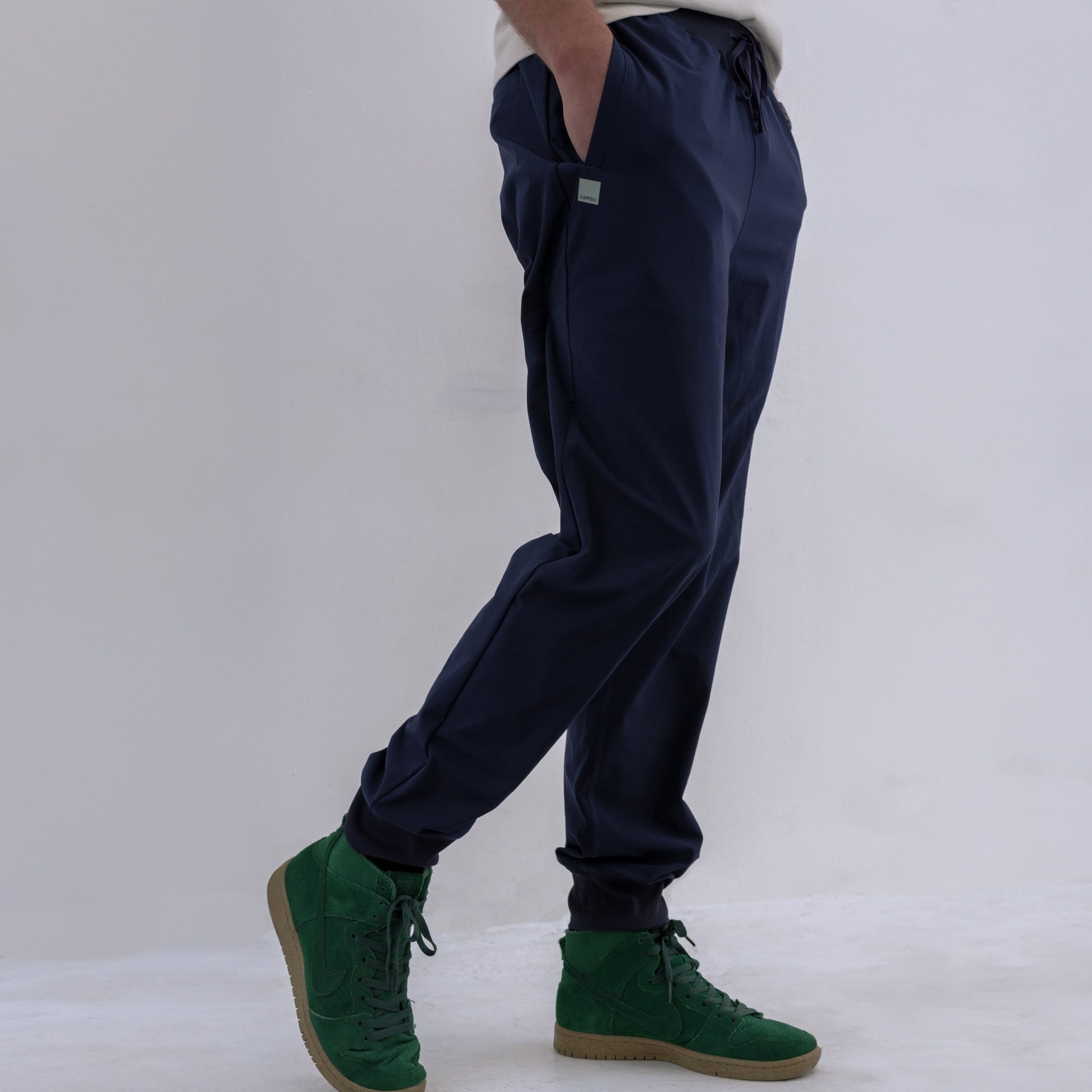 Person wearing navy HAVN WaveStopper™ Joggers with green suede boots, side view showing fit and length.