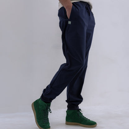 Person wearing navy HAVN WaveStopper™ Joggers with green suede boots, side view showing fit and length.
