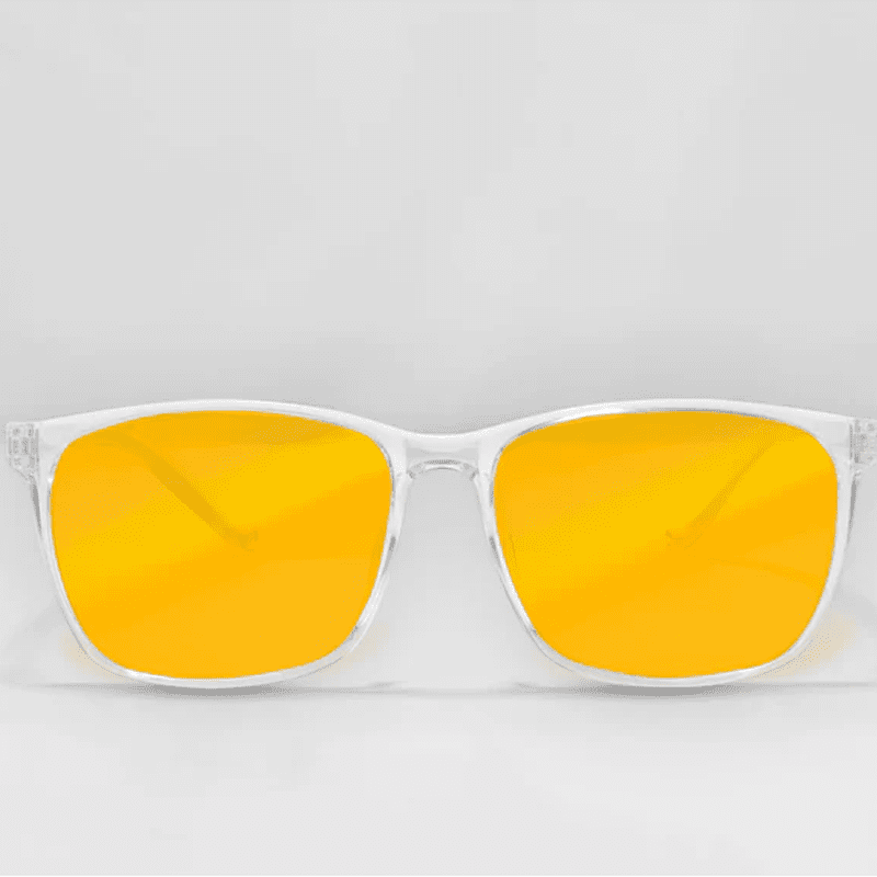 Ocushield Amber blue light glasses with clear frame and bright yellow lenses, front view against gray background.