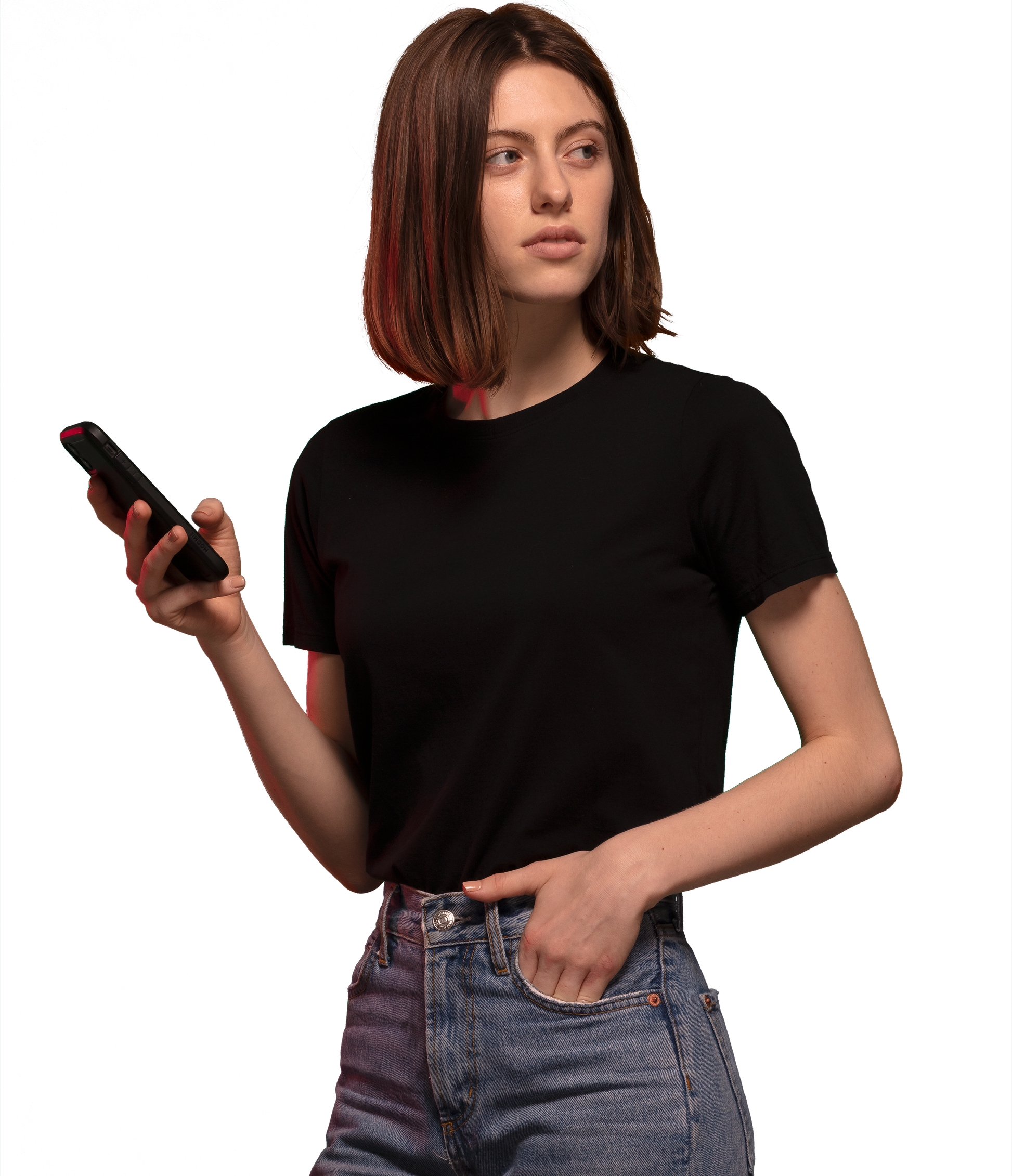 Woman wearing black HAVN WaveStopper™ T-Shirt 2.0 and jeans, holding a smartphone while looking to the side.