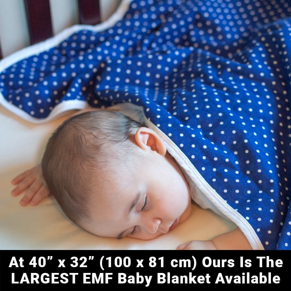 Sleeping infant covered with blue polka dot SYB Baby Blanket, demonstrating size and practical use.