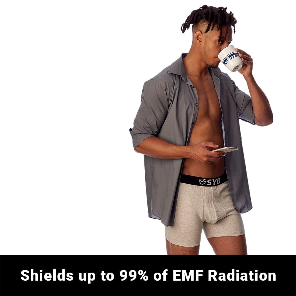 Man wearing SYB boxer briefs while drinking from a cup, demonstrating EMF radiation shielding claim.