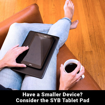 Person holding SYB Tablet Pad on lap with coffee cup, demonstrating size and portability for smaller devices.