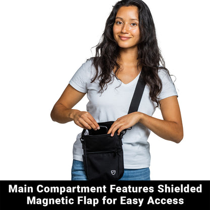 Woman wearing light blue t-shirt holding open SYB Phone Pouch Deluxe with black strap, displaying shielded magnetic flap and main compartment.