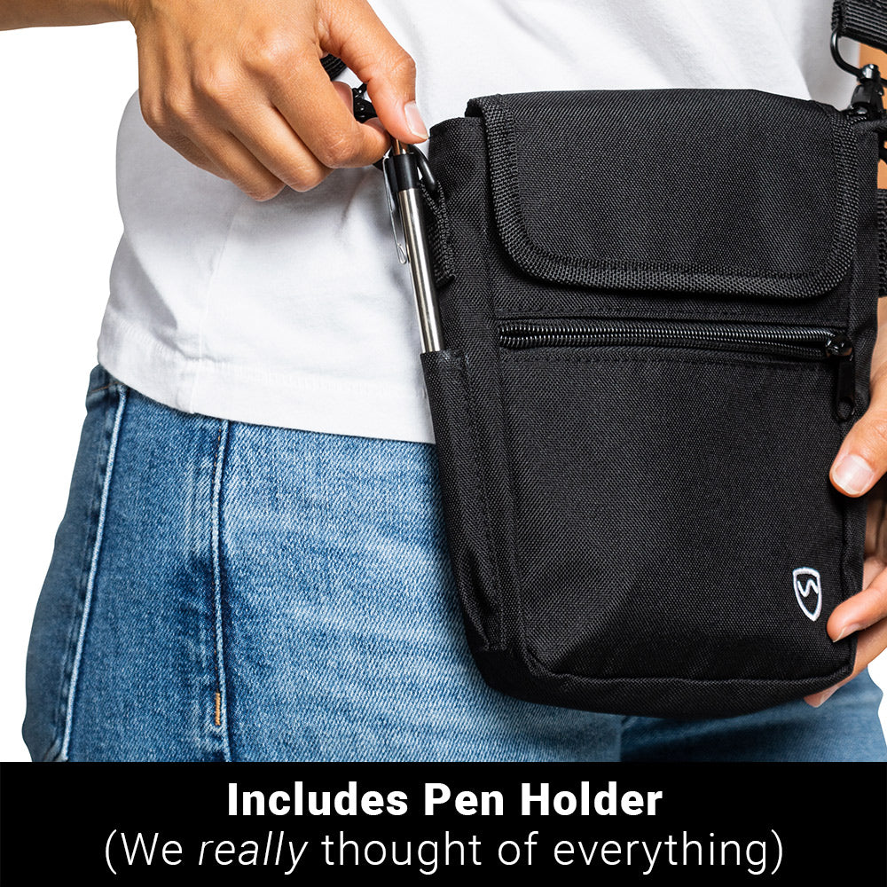 Man holding black SYB Phone Pouch Deluxe with pen in holder, demonstrating pen storage feature on shoulder bag.