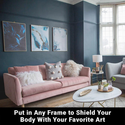 Modern living room with pink sofa and three framed blue artworks on dark teal wall above seating area.