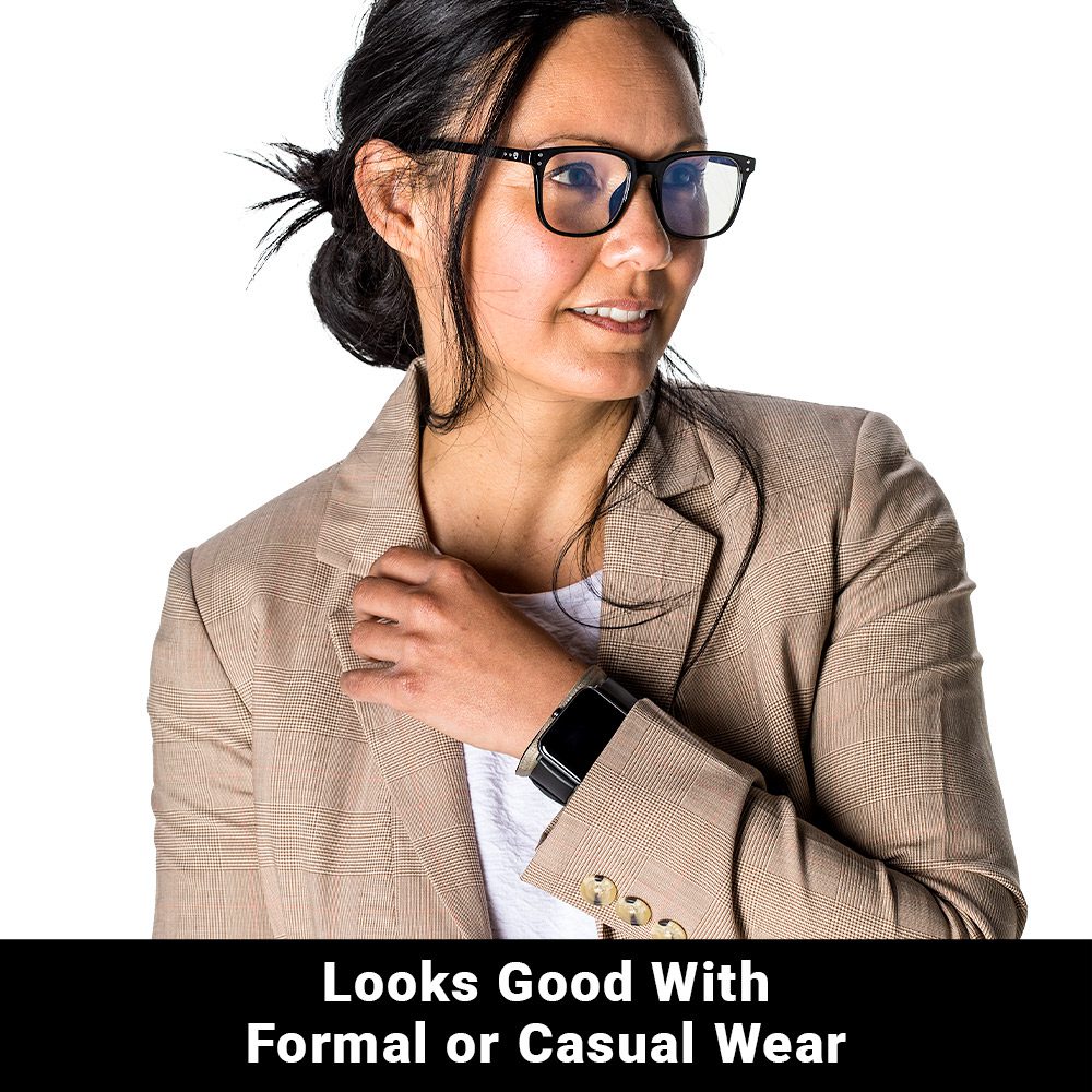Woman wearing beige blazer and SYB Wrist Band on wrist, smiling while looking to the side against white background.